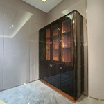 Dark Wood Wine Cabinet with Glass Display Doors, Warm Orange Interior and Stainless Steel Accents
